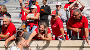 CHARLOTTESVILLE, VA - OCTOBER 08: Fans of the Louisville Cardinals celebrate defeating the Virginia Cavaliers after a game at Scott Stadium on October 8, 2022 in Charlottesville, Virginia. (Photo by Ryan M. Kelly/Getty Images)