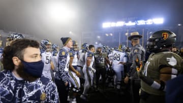 WEST POINT, NY - DECEMBER 12: The Navy Midshipmen and the Army Black Knights shove at midfield after a game at Michie Stadium on December 12, 2020 in West Point, New York. (Photo by Dustin Satloff/Getty Images)