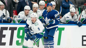 Mar 5, 2022; Toronto, Ontario, CAN; Toronto Maple Leafs left wing Nicholas Robertson (89) skates along the boards with Vancouver Canucks center J.T. Miller (9) during the second period at Scotiabank Arena. Mandatory Credit: Nick Turchiaro-USA TODAY Sports