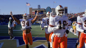 NOVEMBER 20: Defensive end Dwayne Johnson #94 of the University of Miami Hurricanes raises his arms as he and his teammates leave the field during the NCAA game against West Virginia University on November 20, 1993. Dwayne Johnson is also known as "The Rock" of World Wrestling Federation. (Photo by Doug Pensinger/Getty Images)