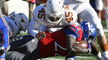 LAWRENCE, KS - NOVEMBER 19: Ke'aun Kinner #22 of the Kansas Jayhawks is tackled by linebacker Anthony Wheeler #45 of the Texas Longhorns in the first quarter at Memorial Stadium on November 19, 2016 in Lawrence, Kansas. (Photo by Ed Zurga/Getty Images)