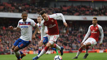 LONDON, ENGLAND - APRIL 01: Mesut Ozil of Arsenal is challenged by Glen Johnson of Stoke City during the Premier League match between Arsenal and Stoke City at Emirates Stadium on April 1, 2018 in London, England. (Photo by Shaun Botterill/Getty Images)