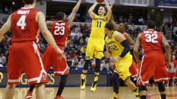 Mar 15, 2014; Indianapolis, IN, USA; Michigan Wolverines guard Nik Stauskas (11) takes a shot against Ohio State Buckeyes center Amir Williams (23) in the semifinals of the Big Ten college basketball tournament at Bankers Life Fieldhouse. Michigan defeats Ohio State 72-69. Mandatory Credit: Brian Spurlock-USA TODAY Sports