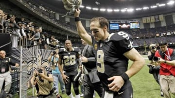 Dec 29, 2013; New Orleans, LA, USA; New Orleans Saints quarterback Drew Brees (9) holds his helmet up to fans as he leaves the field at the Mercedes-Benz Superdome. New Orleans defeated the Tampa Bay Buccaneers 42-17. Mandatory Credit: Crystal LoGiudice-USA TODAY Sports