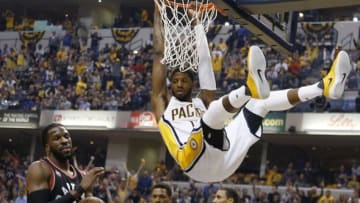 Apr 23, 2016; Indianapolis, IN, USA; Indiana Pacers forward Paul George (13) hangs on the rim after dunking against Toronto Raptors guard Kyle Lowry (7) during the first quarter in game four of the first round of the 2016 NBA Playoffs at Bankers Life Fieldhouse. Mandatory Credit: Brian Spurlock-USA TODAY Sports