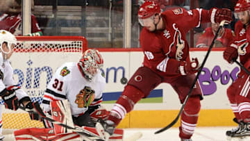 GLENDALE, AZ - NOVEMBER 30: Shane Doan #19 of the Phoenix Coyotes redirects a shot onto Goaltender Antti Raanta #31 of the Chicago Blackhawks at Jobing.com Arena on November 30, 2013 in Glendale, Arizona. (Photo by Norm Hall/NHLI via Getty Images)