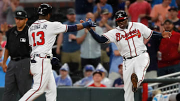 ATLANTA, GA - MAY 16: Ronald Acuna Jr. #13 of the Atlanta Braves reacts with first base coach Eric Young #2 after hitting a RBI single against the Chicago Cubs in the eighth inning to score Ozzie Albies #1 at SunTrust Park on May 16, 2018 in Atlanta, Georgia. (Photo by Kevin C. Cox/Getty Images)