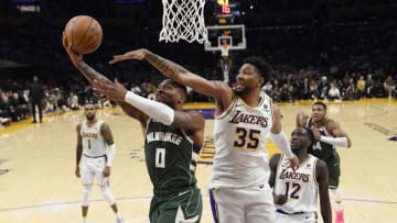 LOS ANGELES, CALIFORNIA - OCTOBER 15: Damian Lillard #0 of the Milwaukee Bucks drives to the basket against Christian Wood #35 of the Los Angeles Lakers during the first half of a preseason basketball game at Crypto.com Arena on October 15, 2023 in Los Angeles, California. NOTE TO USER: User expressly acknowledges and agrees that, by downloading and or using this photograph, User is consenting to the terms and conditions of the Getty Images License Agreement. (Photo by Kevork Djansezian/Getty Images)