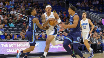 Oct 11, 2022; Orlando, Florida, USA; Orlando Magic forward Paolo Banchero (5) brings the ball up court against Memphis Grizzlies guard Ja Morant (12) and guard Desmond Bane (22) during the first quarter at Amway Center. Mandatory Credit: Mike Watters-USA TODAY Sports