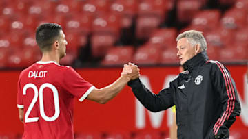 Manchester United's Norwegian manager Ole Gunnar Solskjaer (R) greets Manchester United's Portuguese defender Diogo Dalot at the final whistle during the English Premier League pre-season friendly football match between Manchester United and Brentford at Old Trafford in Manchester, north west England, on July 28, 2021. - RESTRICTED TO EDITORIAL USE. No use with unauthorized audio, video, data, fixture lists, club/league logos or 'live' services. Online in-match use limited to 120 images. An additional 40 images may be used in extra time. No video emulation. Social media in-match use limited to 120 images. An additional 40 images may be used in extra time. No use in betting publications, games or single club/league/player publications. (Photo by Paul ELLIS / AFP) / RESTRICTED TO EDITORIAL USE. No use with unauthorized audio, video, data, fixture lists, club/league logos or 'live' services. Online in-match use limited to 120 images. An additional 40 images may be used in extra time. No video emulation. Social media in-match use limited to 120 images. An additional 40 images may be used in extra time. No use in betting publications, games or single club/league/player publications. / RESTRICTED TO EDITORIAL USE. No use with unauthorized audio, video, data, fixture lists, club/league logos or 'live' services. Online in-match use limited to 120 images. An additional 40 images may be used in extra time. No video emulation. Social media in-match use limited to 120 images. An additional 40 images may be used in extra time. No use in betting publications, games or single club/league/player publications. (Photo by PAUL ELLIS/AFP via Getty Images)