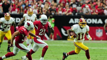 Oct 12, 2014; Glendale, AZ, USA; Washington Redskins wide receiver DeSean Jackson (11) carries the ball for a 64 yard touchdown as Arizona Cardinals cornerback Patrick Peterson (21) and free safety Tyrann Mathieu (32) defend during the first half at University of Phoenix Stadium. Mandatory Credit: Matt Kartozian-USA TODAY Sports