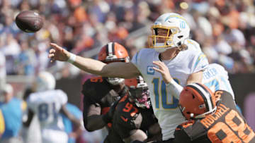 Oct 9, 2022; Cleveland, Ohio, USA; Los Angeles Chargers quarterback Justin Herbert (10) throws a pass as Cleveland Browns defensive end Isaac Rochell (98) and defensive tackle Perrion Winfrey (97) defend during the first half at FirstEnergy Stadium. Mandatory Credit: Ken Blaze-USA TODAY Sports