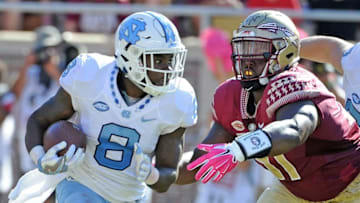 Oct 1, 2016; Tallahassee, FL, USA; North Carolina Tarheels running back T.J. Logan (8) runs past Florida State Seminoles defensive tackle Derrick Nnadi (91) during the game at Doak Campbell Stadium. Mandatory Credit: Melina Vastola-USA TODAY Sports
