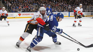 TJ Brodie #7 of the Calgary Flames tries to tie up Mitchell Marner #16 of the Toronto Maple Leafs. (Photo by Claus Andersen/Getty Images)