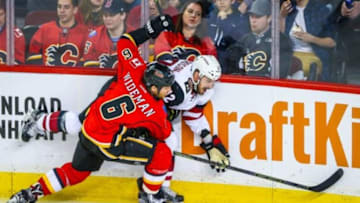 Jan 7, 2016; Calgary, Alberta, CAN; Calgary Flames defenseman Dennis Wideman (6) and Arizona Coyotes center Brad Richardson (12) battle for the puck during the third period at Scotiabank Saddledome. Arizona Coyotes won 2-1. Mandatory Credit: Sergei Belski-USA TODAY Sports