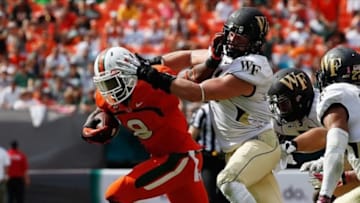Oct 26, 2013; Miami Gardens, FL, USA; Miami Hurricanes running back Duke Johnson (8) stiff arms Wake Forest Demon Deacons linebacker Mike Olson (41) in the second half at Sun Life Stadium. Miami won 24-21. Mandatory Credit: Robert Mayer-USA TODAY Sports