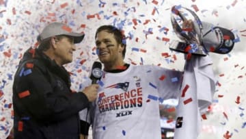 Jan 18, 2015; Foxborough, MA, USA; New England Patriots quarterback Tom Brady (right) holds up the Lamar Hunt Trophy as he is interviewed after the AFC Championship Game against the Indianapolis Colts at Gillette Stadium. Mandatory Credit: David Butler II-USA TODAY Sports