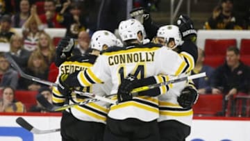 Feb 26, 2016; Raleigh, NC, USA; Boston Bruins forward Patrice Bergeron (37) celebrates with forward Brett Connolly (14) and defensemen Dennis Seidenberg (44) after scoring a goal in the first period against the Carolina Hurricanes at PNC Arena. Mandatory Credit: James Guillory-USA TODAY Sports