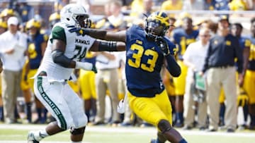 Sep 3, 2016; Ann Arbor, MI, USA; Michigan Wolverines defensive end Taco Charlton (33) rushes on Hawaii Warriors offensive lineman RJ Hollis (74) at Michigan Stadium. Mandatory Credit: Rick Osentoski-USA TODAY Sports