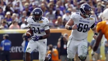 Jan 1, 2016; Tampa, FL, USA; Northwestern Wildcats running back Justin Jackson (21) runs the ball against the Tennessee Volunteers in the first half at the 2016 Outback Bowl at Raymond James Stadium. Mandatory Credit: Mark Zerof-USA TODAY Sports