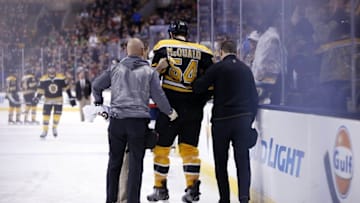 Jan 5, 2016; Boston, MA, USA; Boston Bruins defenseman Adam McQuaid (54) is helped off the ice after he was checked into the boards by Washington Capitals center Zach Sill (not pictured) during the second period at TD Garden. Mandatory Credit: Greg M. Cooper-USA TODAY Sports