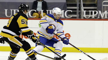May 8, 2021; Pittsburgh, Pennsylvania, USA; Buffalo Sabres center Arttu Ruotsalainen (25) moves the puck against Pittsburgh Penguins left wing Jake Guentzel (59) during the first period at PPG Paints Arena. Mandatory Credit: Charles LeClaire-USA TODAY Sports