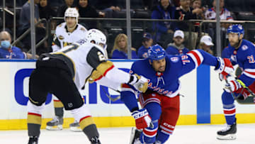 NEW YORK, NEW YORK - DECEMBER 17: Shea Theodore #27 of the Vegas Golden Knights checks Ryan Reaves #75 of the New York Rangers at Madison Square Garden on December 17, 2021 in New York City. The Golden Knights defeated the Rangers 3-2 in the shootout. (Photo by Bruce Bennett/Getty Images)