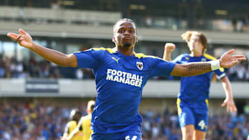 WIMBLEDON, ENGLAND - AUGUST 14: Dapo Mebude of AFC Wimbledon celebrates after scoring their team's third goal during the Sky Bet League One match between AFC Wimbledon and Bolton Wanderers at Plough Lane on August 14, 2021 in Wimbledon, England. (Photo by Jacques Feeney/Getty Images)