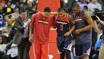 Mar 25, 2015; Washington, DC, USA; Washington Wizards guard Bradley Beal (3) is helped off the court against the Indiana Pacers after suffering an apparent ankle injury during the first half at Verizon Center. Mandatory Credit: Brad Mills-USA TODAY Sports