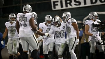 OAKLAND, CALIFORNIA - NOVEMBER 07: Josh Jacobs #28 of the Oakland Raiders is congratulated by teammates including Derek Carr #4 after he ran the ball in for the winning touchdown against the Los Angeles Chargers in the fourth quarter at RingCentral Coliseum on November 07, 2019 in Oakland, California. (Photo by Ezra Shaw/Getty Images)