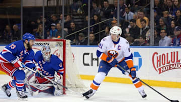 Mar 6, 2016; New York, NY, USA; New York Islanders center John Tavares (91) controls the puck against New York Rangers defenseman Keith Yandle (93) and New York Rangers goalie Antti Raanta (32) during the first period at Madison Square Garden. Mandatory Credit: Brad Penner-USA TODAY Sports