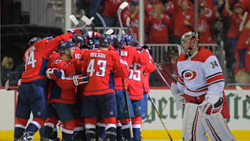 WASHINGTON, DC - APRIL 13: Carolina Hurricanes goaltender Petr Mrazek (34), right, glances at the Washington Capitals mobbing their terammate Washington Capitals defenseman Brooks Orpik (44) after he scored the winning OT goal during a game between the Washington Capitals and the Carolina Hurricanes in game 2 of the Stanley Cup Eastern Conference quarterfinals in Washington, DC on April 13, 2019 . (Photo by John McDonnell/The Washington Post via Getty Images)