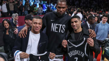 Jan 2, 2023; Brooklyn, New York, USA; Paris Saint-Germain and French national forward Kylian Mbappe (left) and PSG teammate defender Achraf Hakimi (right) pose for a photo with Brooklyn Nets forward Kevin Durant (7) after the game against the San Antonio Spurs at Barclays Center. Mandatory Credit: Vincent Carchietta-USA TODAY Sports