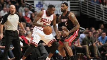 Dec 5, 2013; Chicago, IL, USA; Chicago Bulls small forward Luol Deng (9) is defended by Miami Heat small forward LeBron James (6) during the second half at the United Center. The Bulls beat the Heat 107-87. Mandatory Credit: Rob Grabowski-USA TODAY Sports