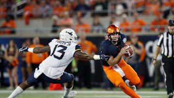 ORLANDO, FL - DECEMBER 28: Eric Dungey #2 of the Syracuse Orange tries to avoid pressure from Jeffery Pooler Jr. #13 of the West Virginia Mountaineers in the first quarter of the Camping World Bowl at Camping World Stadium on December 28, 2018 in Orlando, Florida. (Photo by Joe Robbins/Getty Images)
