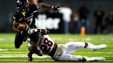 Cincinnati Bearcats wide receiver Tre Tucker is tackled by Temple Owls safety MJ Griffin. The Enquirer.
