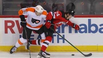 Jan 28, 2021; Newark, New Jersey, USA; Philadelphia Flyers center Connor Bunnaman (82) hits New Jersey Devils defenseman Ty Smith (24) during the third period at Prudential Center. Mandatory Credit: Ed Mulholland-USA TODAY Sports