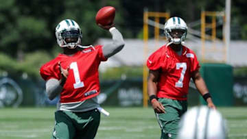 Jul 24, 2014; Cortland, NY, USA; New York Jets quarterback Michael Vick (1) passes the ball as quarterback Geno Smith (7) looks on during training camp at SUNY Cortland. Mandatory Credit: Rich Barnes-USA TODAY Sports