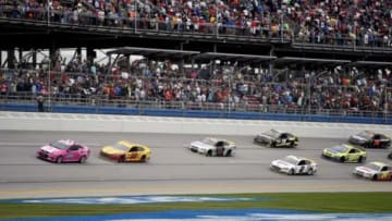 Oct 25, 2015; Talladega, AL, USA; A pace card leads Sprint Cup Series driver Joey Logano (22) and the pack during the last lap under the caution flag the Campingworld.com 500 at Talladega Superspeedway. Mandatory Credit: John David Mercer-USA TODAY Sports