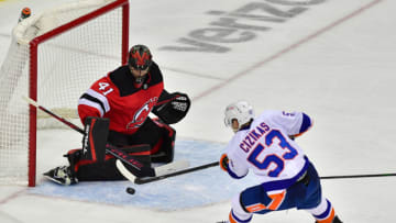 Mar 14, 2021; Newark, New Jersey, USA; New Jersey Devils goalie Scott Wedgewood (41) blocks a shot by New York Islanders center Casey Cizikas (53) during overtime at Prudential Center. Mandatory Credit: Catalina Fragoso-USA TODAY Sports