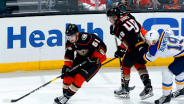 ANAHEIM, CA - JANUARY 23: Troy Terry #61 and Max Jones #49 of the Anaheim Ducks battle for the puck against Jay Bouwmeester #19 of the St. Louis Blues during the game on January 23, 2019 at Honda Center in Anaheim, California. (Photo by Debora Robinson/NHLI via Getty Images)