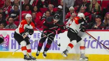 Nov 15, 2023; Raleigh, North Carolina, USA; Carolina Hurricanes center Seth Jarvis (24) side steps a check by Philadelphia Flyers defensemen Louie Belpedio (37) during the third period at PNC Arena. Mandatory Credit: James Guillory-USA TODAY Sports