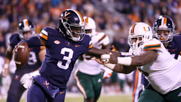 CHARLOTTESVILLE, VA - OCTOBER 13: Bryce Perkins #3 of the Virginia Cavaliers stiff arms Gerald Willis III #9 of the Miami Hurricanes in the first half during a game at Scott Stadium on October 13, 2018 in Charlottesville, Virginia. (Photo by Ryan M. Kelly/Getty Images)