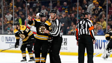BOSTON, MA - MAY 12: Boston Bruins left wing Brad Marchand (63) is held back by linesman Devin Berg (87) but shows Carolina Hurricanes right wing Justin Williams (14) the way to the penalty box during Game 2 of the Stanley Cup Playoffs Eastern Conference Finals on May 12, 2019, at TD Garden in Boston, Massachusetts. (Photo by Fred Kfoury III/Icon Sportswire via Getty Images)