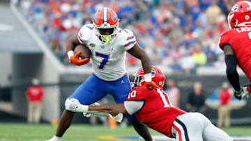 Oct 29, 2022; Jacksonville, Florida, USA; Florida Gators running back Trevor Etienne (7) runs with the ball as Georgia Bulldogs linebacker Jamon Dumas-Johnson (10) tackles during the second quarter at TIAA Bank Field. Mandatory Credit: Kim Klement-USA TODAY Sports