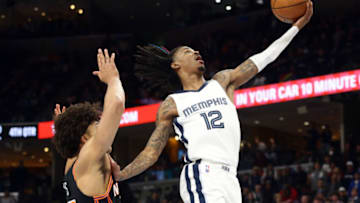 Mar 11, 2022; Memphis, Tennessee, USA; Memphis Grizzlies guard Ja Morant (12) drives to the basket as New York Knicks center Jericho Sims (45) defends during the second half at FedExForum. (Petre Thomas-USA TODAY Sports)