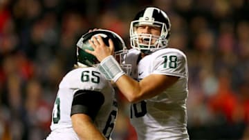 PISCATAWAY, NJ - OCTOBER 10: Brian Allen #65 and Connor Cook #18 of the Michigan State Spartans celebrate a touchdown by teammate LJ Scott in the fourth quarter against the Rutgers Scarlet Knights on October 10, 2015 at High Point Solutions Stadium in Piscataway, New Jersey.The Michigan State Spartans defeated the Rutgers Scarlet Knights 31-24. (Photo by Elsa/Getty Images)