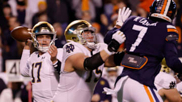 Nov 13, 2021; Charlottesville, Virginia, USA; Notre Dame Fighting Irish quarterback Jack Coan (17) passes the ball as Virginia Cavaliers outside linebacker Noah Taylor (7) defends during the first quarter at Scott Stadium. Mandatory Credit: Geoff Burke-USA TODAY Sportsa