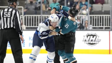SAN JOSE, CALIFORNIA - OCTOBER 16: Logan Stanley #64 of the Winnipeg Jets and Jacob Middleton #21 of the San Jose Sharks fight during the second period at SAP Center on October 16, 2021 in San Jose, California. (Photo by Thearon W. Henderson/Getty Images)