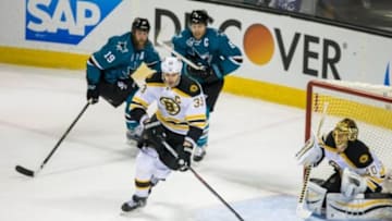 Mar 15, 2016; San Jose, CA, USA; Boston Bruins defenseman Zdeno Chara (33) clears the puck as San Jose Sharks center Joe Thornton (19) and center Joe Pavelski (8) chase him in the first period at SAP Center at San Jose. Mandatory Credit: John Hefti-USA TODAY Sports.